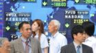 epa02230458 Japanese pedestrians stand in front of a stock index board showing global stock market's tumbling figures in down