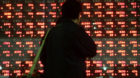 A man is silhouetted as he stops by a stock indicator in Tokyo Wednesday, Feb. 21, 2007.  After Japan's central bank announce