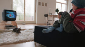 Kinder schauen sich im Wohnzimmer eine Fernsehsendung an, aufgenommen am 24. April 2004 in Zuerich. (KEYSTONE/Gaetan Bally)  