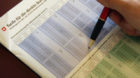 Ein Steuerberater informiert sich im Zusatzblatt der Steuererklaerung "Tarife fuer die direkte Bundessteuer" ueber die ungefa