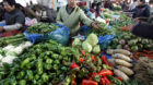 In this photo taken Dec. 9, 2012, a vegetable vendor attends to a customer at a market in Nanjing in eastern China's Jiangsu 