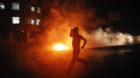 A protester runs for cover as police use water cannons and tear gas against a crowd of about 200 protesters in Istanbul's Gaz