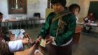 A Bhutanese polling official puts the indelible ink mark on the finger of a voter before she proceeds to cast her vote for th
