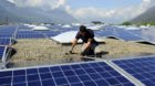 Ein Arbeiter installiert Solarpanelen auf dem Dach der Firma Debrunner AG, am Mittwoch, 24. April 2013, in Giubiasco. Nach Fe