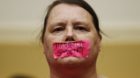 Protester Ellen Taylor wears tape over her mouth to protest against the use of military strikes by the U.S. on Syria, as she 