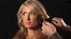 American socialite Paris Hilton has her hair fixed as she poses for portraits in New York on September 25, 2013.        REUTE