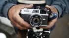 Iordan Lenin, 49, a Roma man, displays a vintage Canon camera at an encampment of Roma families in Triel-sur-Seine, near Pari