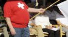 Ein Mann mit dem Schweizerkreuz auf dem T-Shirt haelt eine Flagge, anlaesslich einer Veranstaltung zur Bundesfeier, am Sonnta