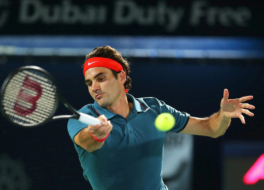 epa04099086 Roger Federer of Switzerland returns the ball to Benjamin Becker of Germany  during their first round match of the Dubai Duty Free Tennis ATP Championships in Dubai, United Arab Emirates, 24 February 2014.  EPA/ALI HAIDER