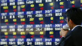 A man drinks coffee in front of a securities firm's electronic stock board in Tokyo, Wednesday, Jan. 29, 2014. Global stock m
