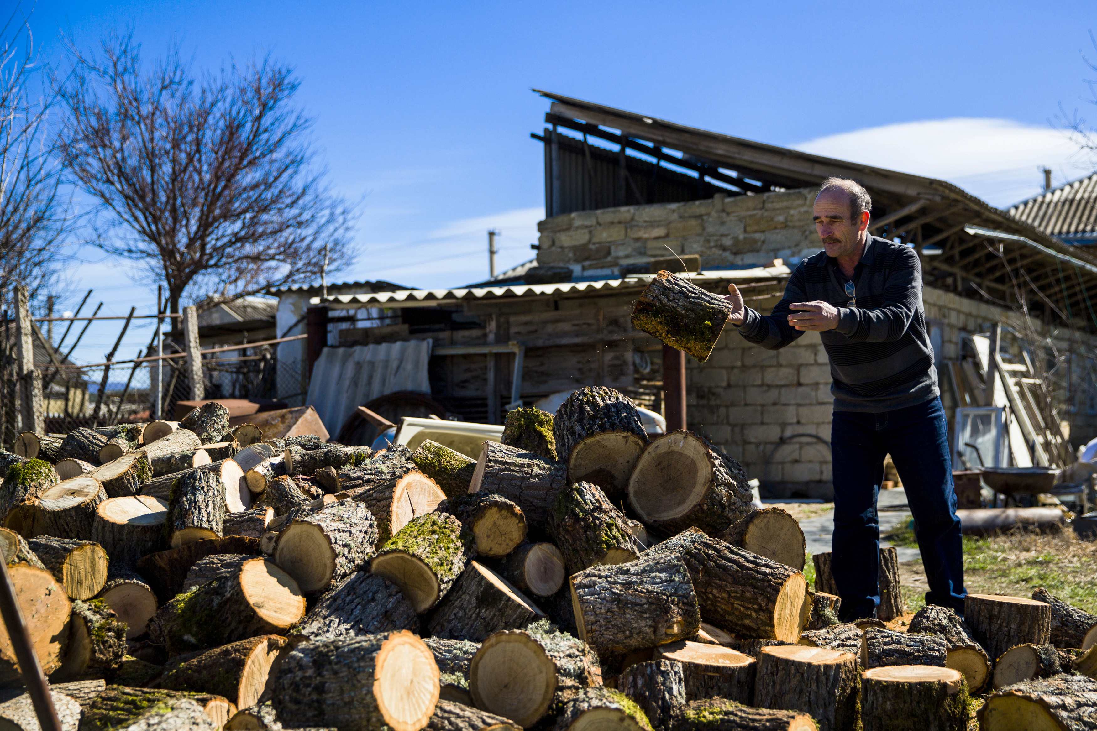 A Crimean Tartar piles up wood in his garden in Belogorsk near the Crimean capital of Simferopol March 17, 2014. Among the voices drowned out by victory celebrations across Crimea as it voted to leave Ukraine and join Russia were those of the Tatars, a mi