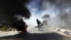 A Palestinian protester runs during clashes with Israeli troops at a protest calling for the release of Palestinian prisoners