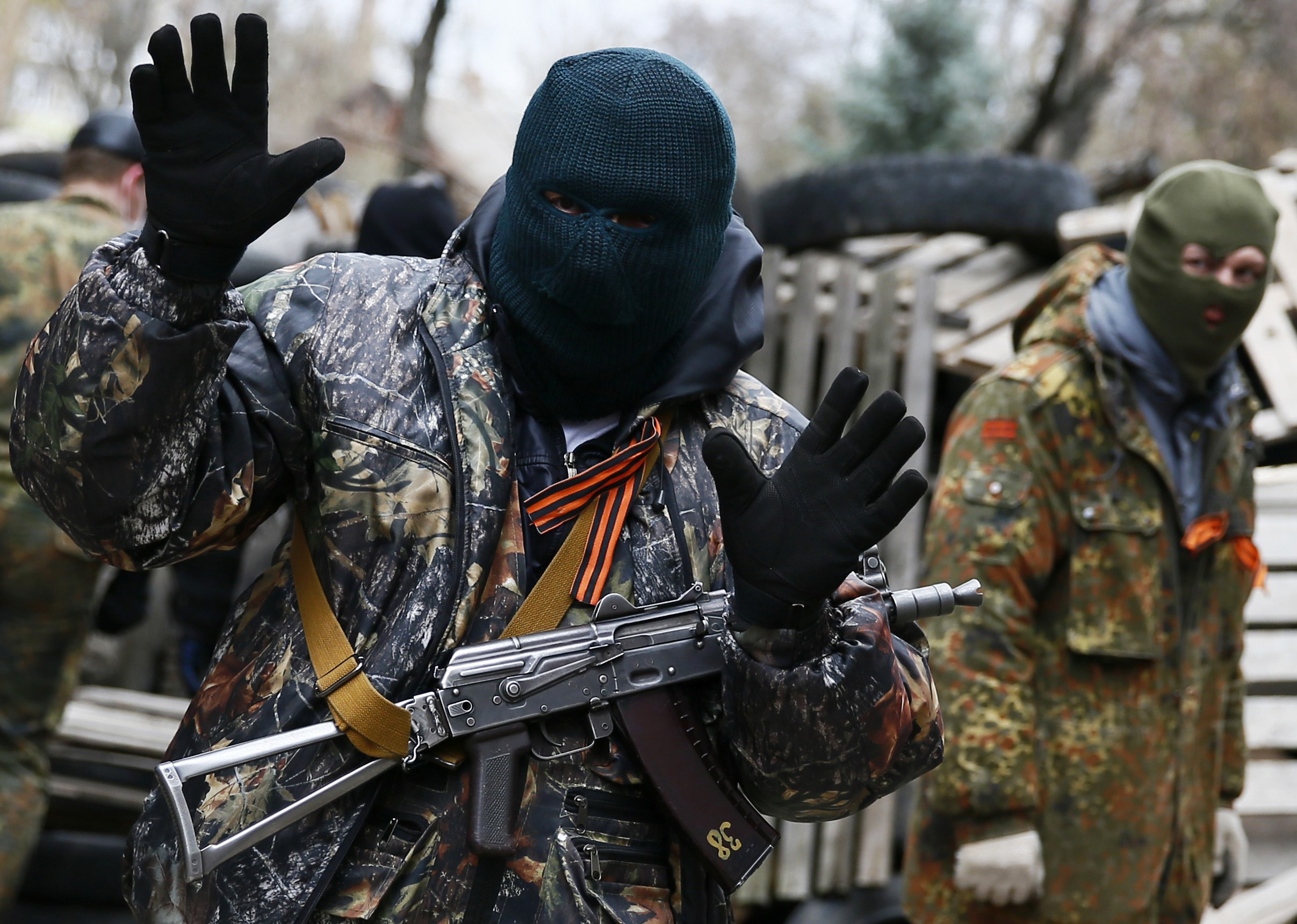 An armed man gestures in front of the police headquarters in Slaviansk, April 12, 2014. At least 20 armed militants wearing mismatched camouflage outfits took over the police and security services headquarters in the eastern city of Slaviansk seizing hund