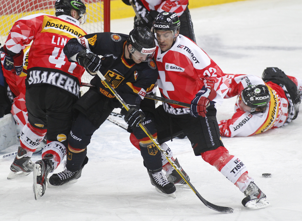 Germany's Daniel Pietta, center left, collides with Switzerland's Victor Stancescu as they fight for the third place during their ice hockey Four Nations BelSwissBank Cup tournament in Minsk, Belarus, Saturday, Feb. 11, 2012. Switzerland won 1-0. (AP Phot