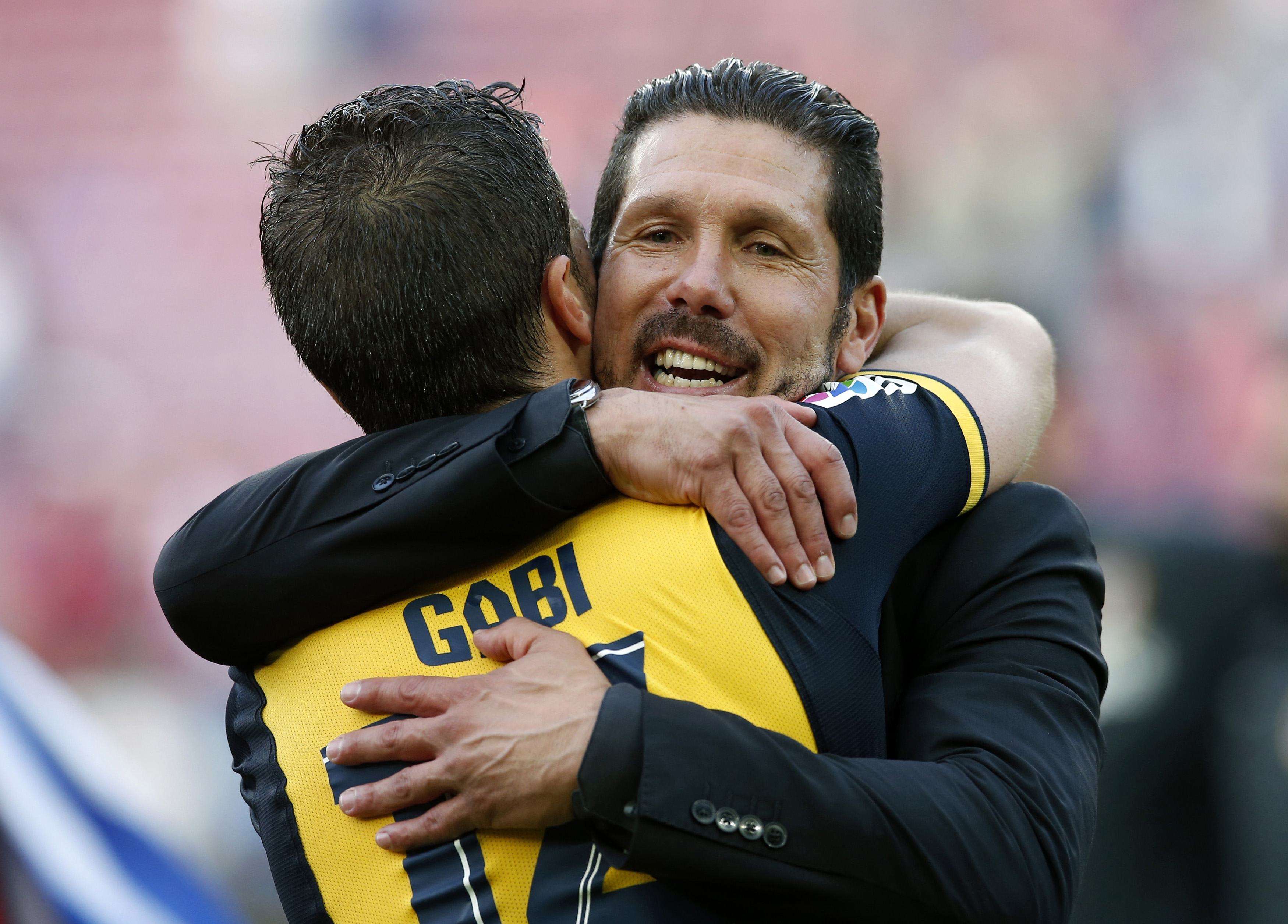 Atletico Madrid's coach Diego Simeone (R) embraces captain Gabi after winning the Spanish first division title following their soccer match against Barcelona at Camp Nou stadium in Barcelona May 17, 2014. REUTERS/Albert Gea (SPAIN - Tags: SPORT SOCCER)