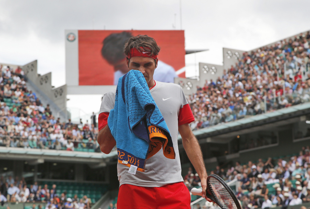 Switzerland's Roger Federer wipes his face  during the third round match of the French Open tennis tournament against Russia's Dmitry Tursunov at the Roland Garros stadium, in Paris, France, Friday, May 30, 2014.  (AP Photo/Michel Euler)