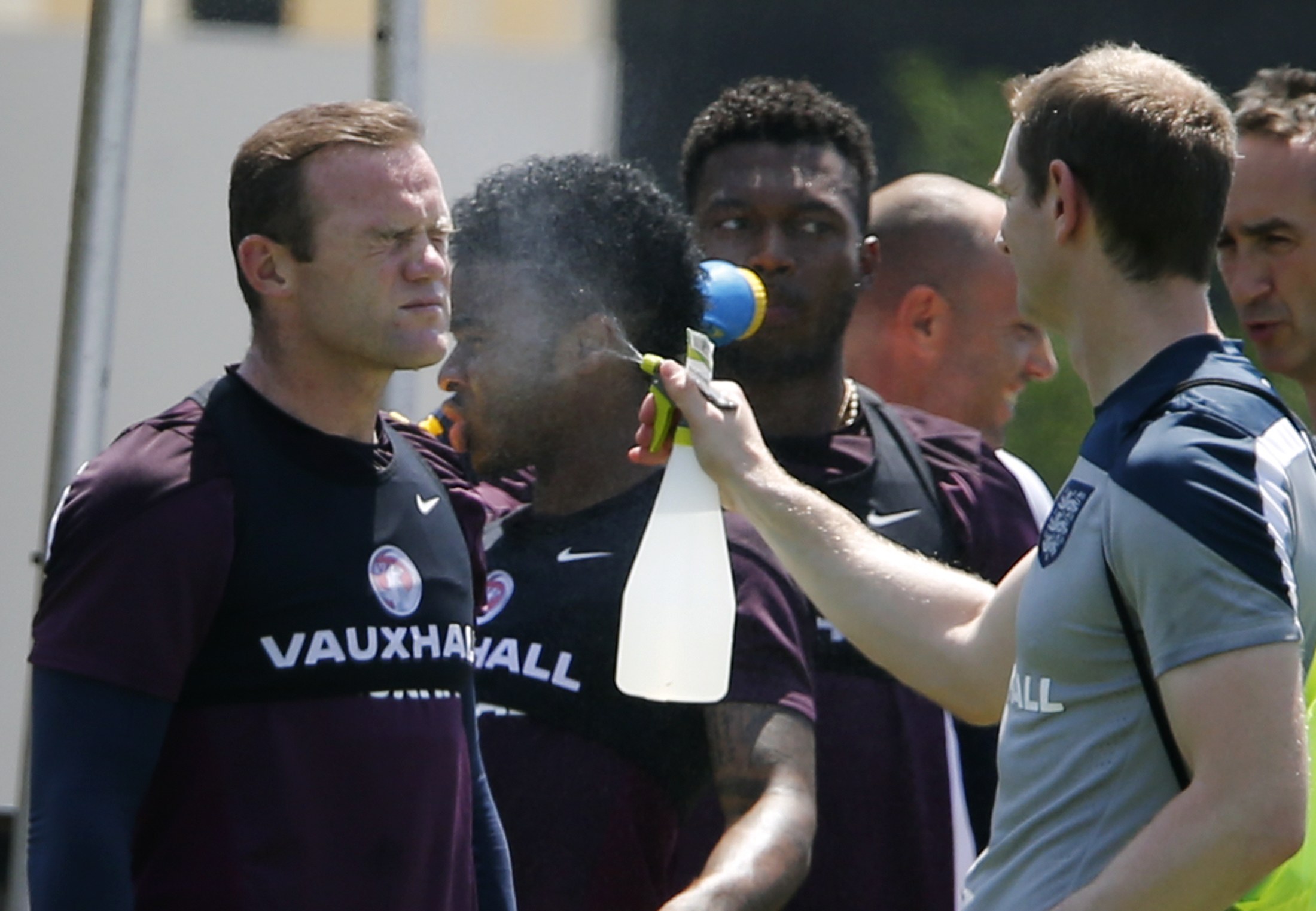 England's Wayne Rooney (L) is sprayed with water for cooling down as Raheem Sterling (2nd L) and Daniel Sturridge (3rd L) look on during a training session of the England soccer squad ahead of the 2014 World Cup in Miami June 6, 2014.  REUTERS/Wolfgang Ra