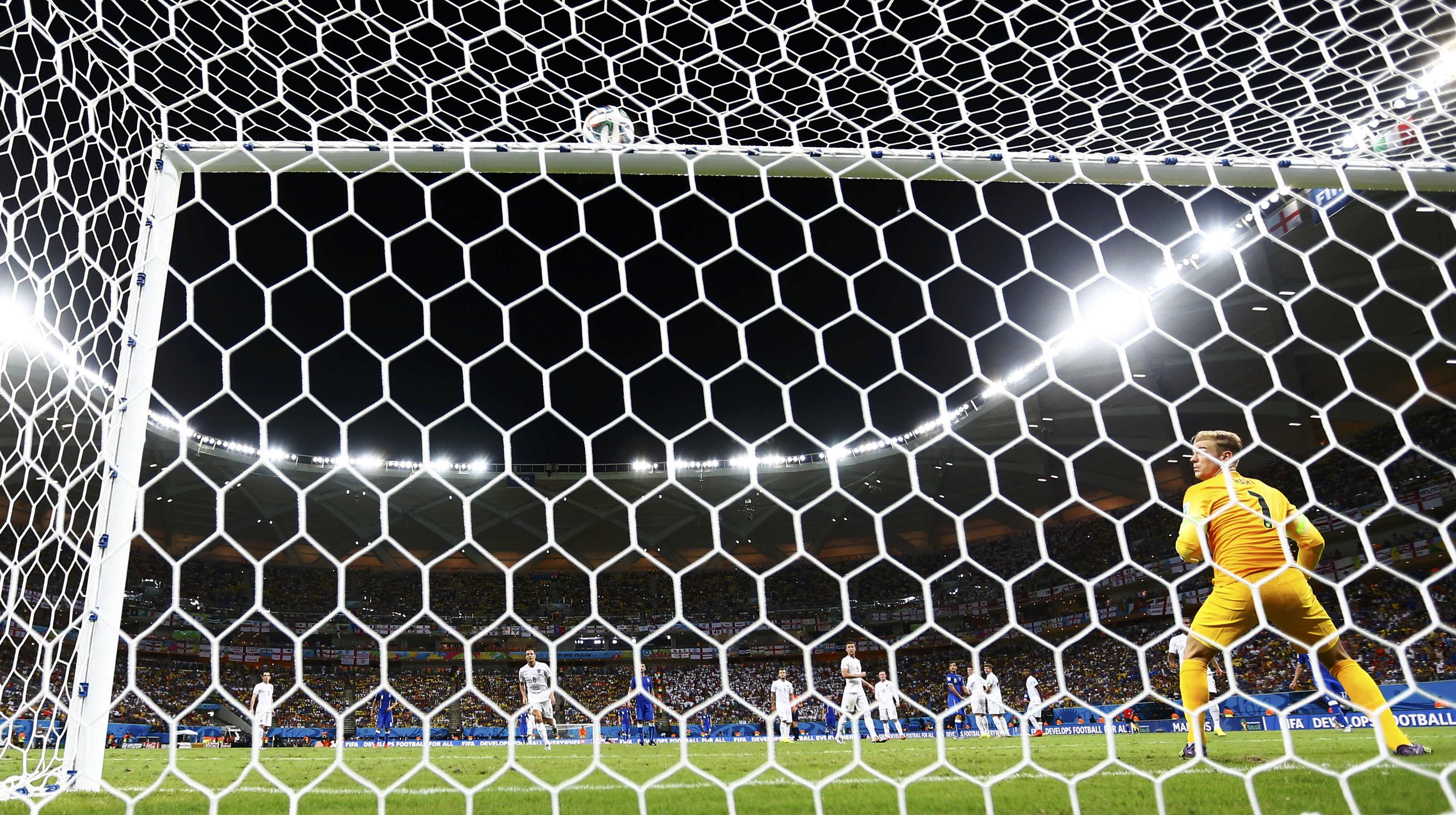 England's Joe Hart (R) watches as the ball from Italy's Andrea Pirlo's freekick hits the crossbar during their 2014 World Cup Group D soccer match at the Amazonia arena in Manaus June 14, 2014.  REUTERS/Kai Pfaffenbach (BRAZIL  - Tags: TPX IMAGES OF THE D