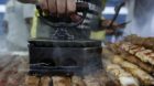 A vendor prepares meat skewers on a street in Belo Horizonte June 19, 2014. In a project called "On The Sidelines" Reuters ph