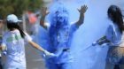 A participant (C) reacts as he is sprayed with coloured powder during a 5-kilometre Color Run in Shenyang, Liaoning province 