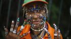 A street cleaner and fan of the Brazilian national World Cup soccer team shows the myriad of piercings on her face, and her s