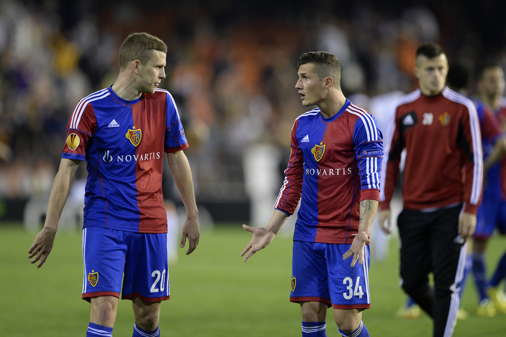FC Basel's disappointed players Basel's Fabian Frei, left, and Basel's Taulant Xhaka, right, leave the pitch after the UEFA Europa League quarter final second leg soccer match between Spain's Valencia CF and Switzerland's FC Basel 1893 at the Mestalla sta