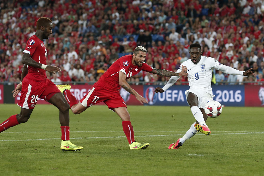 England's forward Danny Welbeck , right, scores the goal for 0-2 next to Swiss midfielder Valon Behrami, center, and Johan Djourou, left, during the UEFA EURO 2016 qualifying match Switzerland against England at the St. Jakob-Park stadium in Basel, Switze