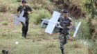 Lebanese Army soldiers carry parts of an Israeli drone in the Marjeyoun countryside, south Lebanon September 20, 2014. The Le