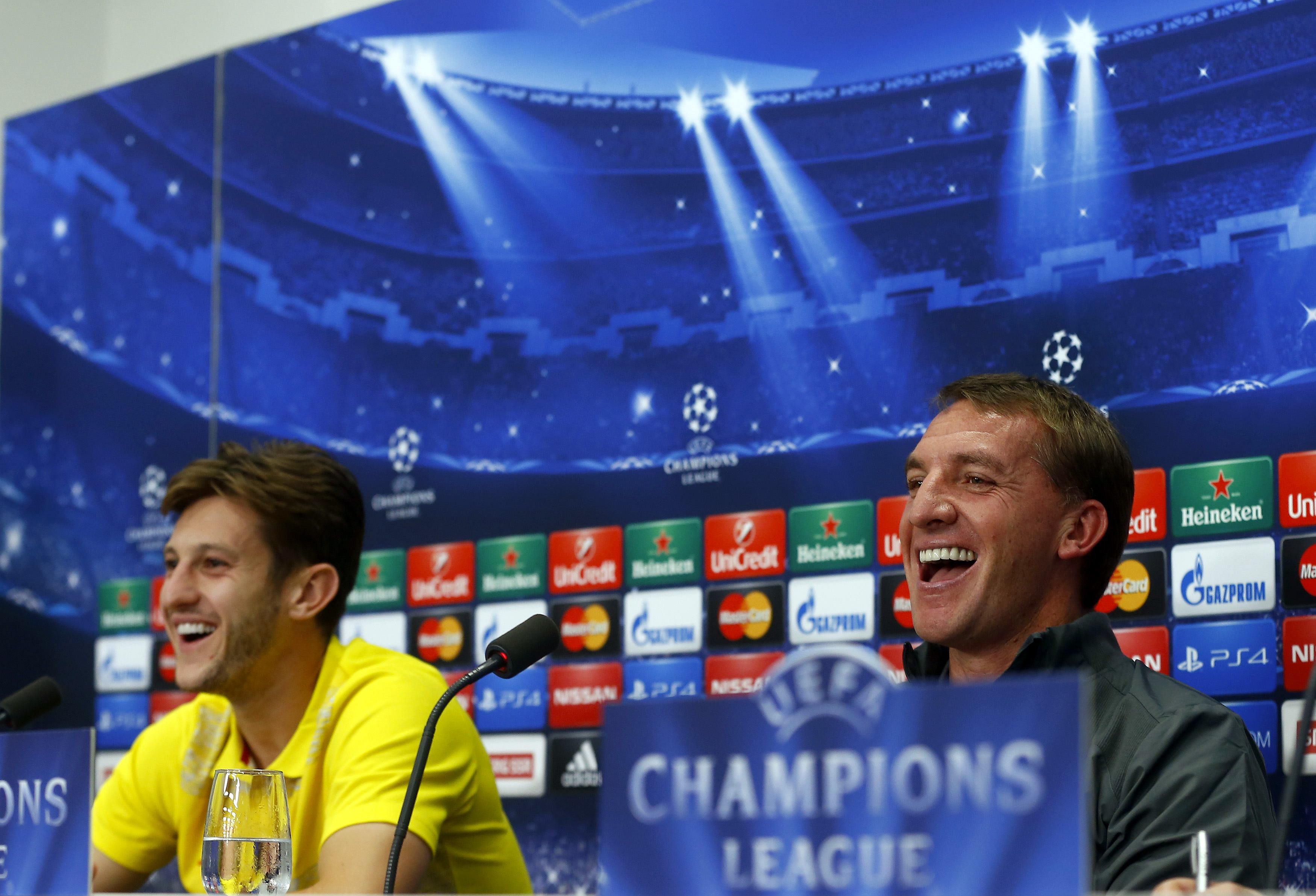 Liverpool's player Adam Lallana and manager Brendan Rodgers (R) smile during a news conference ahead of their Champions League Group B match against FC Basel in Basel September 30, 2014. REUTERS/Arnd Wiegmann (SWITZERLAND - Tags: SPORT SOCCER HEADSHOT)