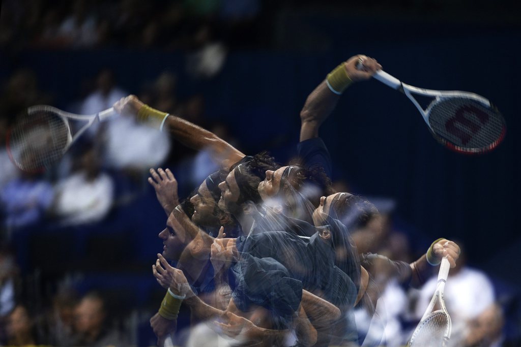 Multiple exposure of Switzerland's Roger Federer serving a ball to Uzbekistan's Denis Istomin during their second round match at the Swiss Indoors tennis tournament at the St. Jakobshalle in Basel, Switzerland, on Wednesday, October 23, 2013. (KEYSTONE/Ge