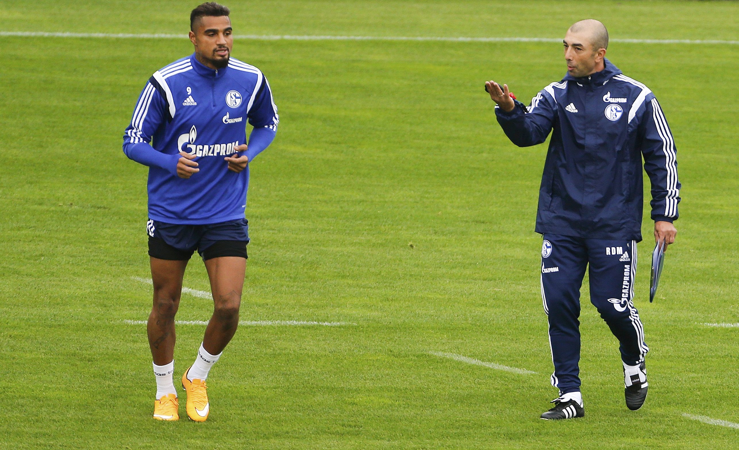Schalke 04's new coach Roberto Di Matteo reacts next to player Kevin-Prince Boateng (L) during his first training session as Schalke 04's head coach in Gelsenkirchen October 9, 2014. Schalke 04 appointed Di Matteo, former coach of the 2012 Champions League winner FC Chelsea, as a replacement for Jens Keller, who was sacked on Tuesday after an inconsistent start to the season. REUTERS/Wolfgang Rattay (GERMANY - Tags: SOCCER SPORT)