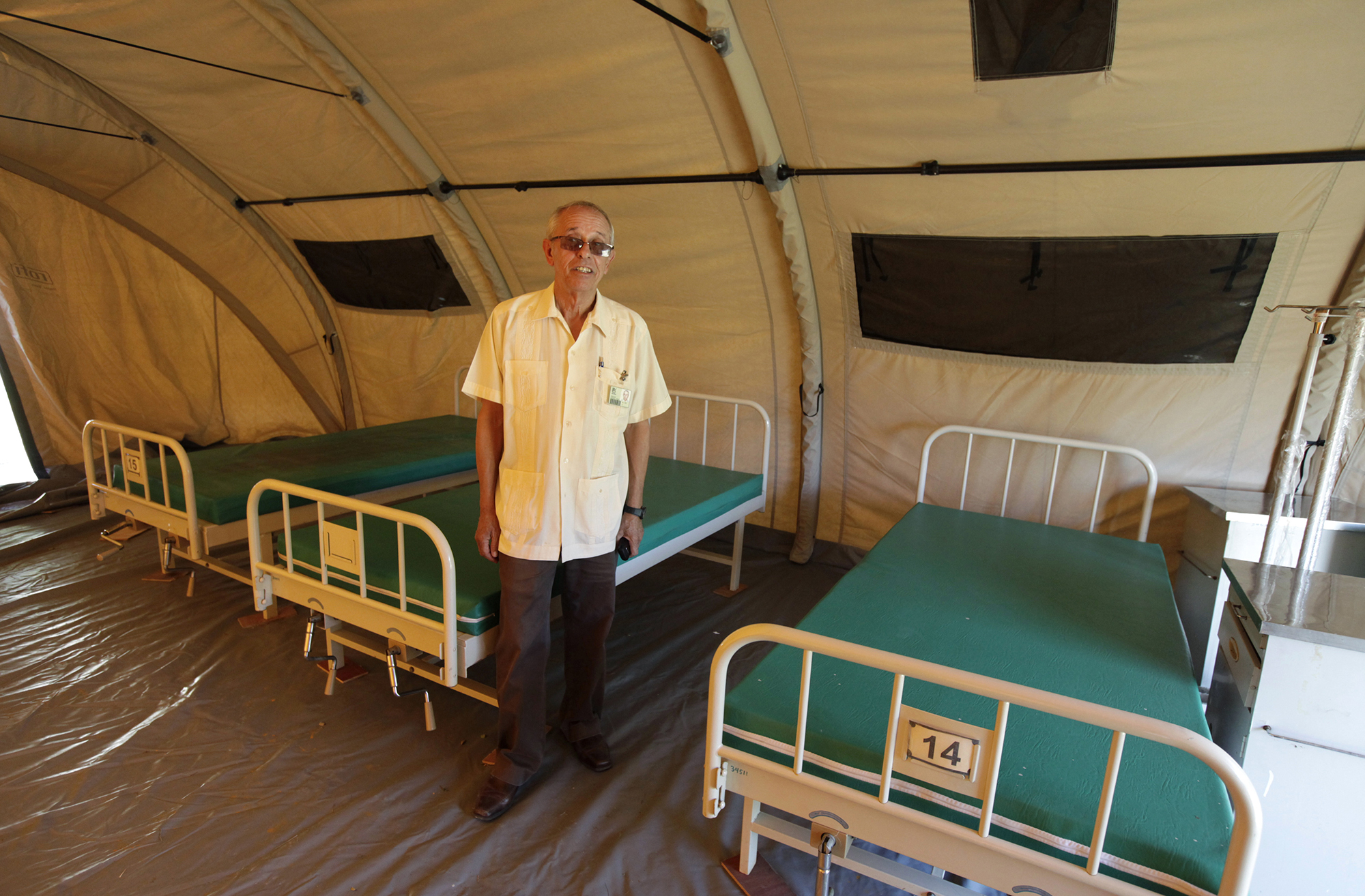 Jorge Perez, director of the Pedro Kouri Tropical Medicine Institute, where Cuban doctors train for their Ebola mission, poses for a picture in a tent set up for training purposes in Havana October 17, 2014. Cuban doctors and U.S. military personnel could work side-by-side in West Africa as part of international efforts to contain the Ebola outbreak, possibly leading to improved bilateral relations, a top Cuban health official said on Friday. The two long-time adversaries are among the countries aiding West Africa, where Ebola has killed some 4,546 people since the outbreak of the hemorrhagic fever began there in March. The Cuban medical personnel undergo three weeks of training at the Pedro Kouri Tropical Medicine Institute on the outskirts of Havana, where health officials set up a field hospital of tents to simulate conditions in West Africa. REUTERS/Enrique De La Osa (CUBA - Tags: HEALTH SOCIETY) - RTR4AMO7