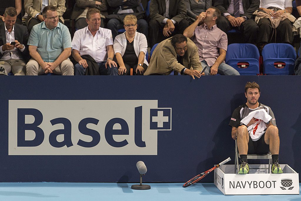 epa04456619 Switzerland's Stanislas Wawrinka sits down due to a blackout of the electric lighting during his first round match against Kazakhstan's Mikhail Kukushkin at the Swiss Indoors tennis tournament at the St. Jakobshalle in Basel, Switzerland, 21 October 2014. EPA/GEORGIOS KEFALAS