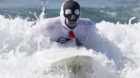 A competitor rides a wave during the 7th annual ZJ Boarding House Haunted Heats Halloween surf contest in Santa Monica, Calif