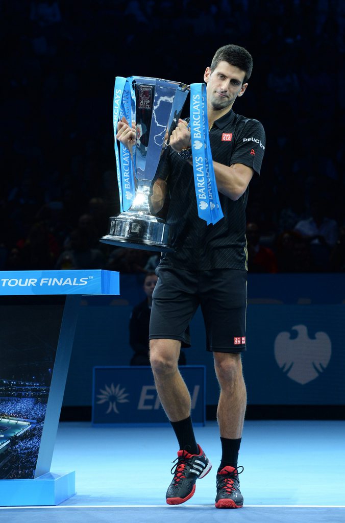 epa04492488 Novak Djokovic from Serbia poses with the trophy after Switzerland's Roger Federer pulled out of the final through injury at the ATP World Tour Finals tennis tournament at the O2 Arena in London, Britain, 16 November 2014. EPA/ANDY RAIN