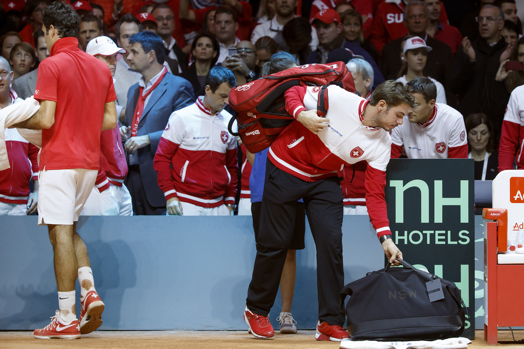 Schöne Geste: Stan Wawrinka trägt Roger Federers Utensilien nach dem Match vom Platz.