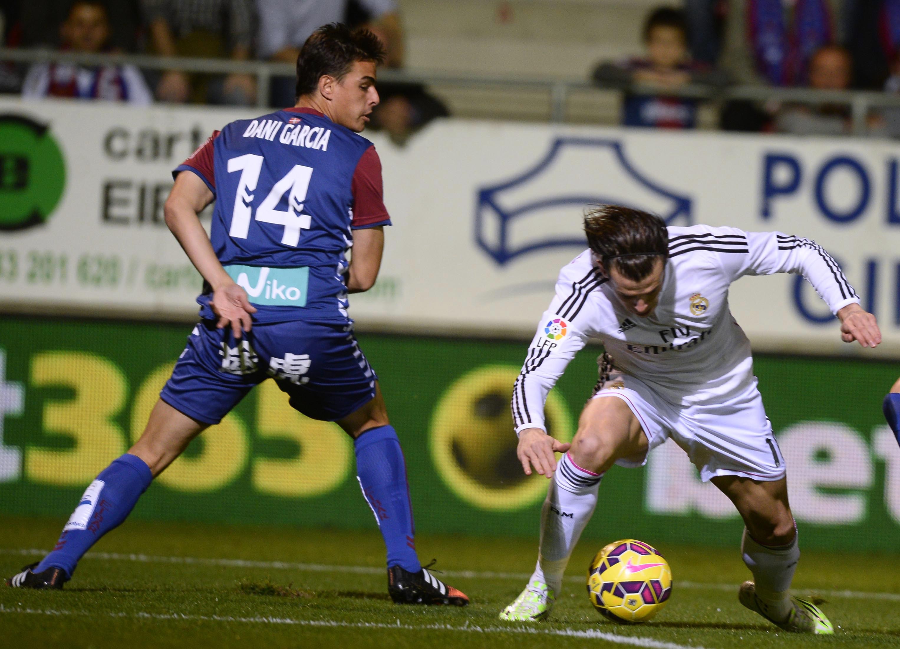 Real Madrid's Gareth Bale (R) fights for the ball with Eibar's Dani Garcia during their Spanish first division soccer match at Ipurua stadium in Eibar November 22, 2014. REUTERS/Vincent West (SPAIN - Tags: SPORT SOCCER)