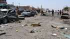 Civilians and security forces inspect the site of a suicide bomb attack in Tuz Khormato, 130 miles (210 kilometers) north of 