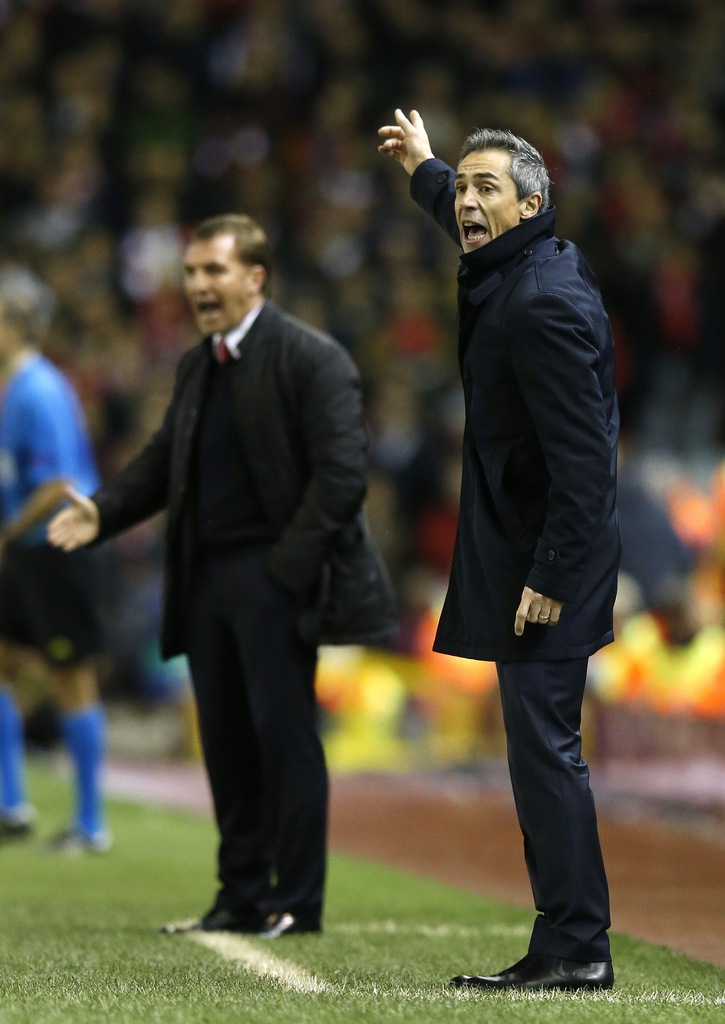 Basel's head coach Paulo Sousa, right, and Liverpool's head coach Brendan Rodgers shout out from the touchline during the Champions League Group B soccer match between Liverpool and FC Basel at Anfield Stadium in Liverpool, England, Tuesday, Dec. 9, 2014. (AP Photo/Jon Super)