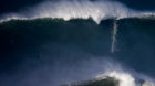 A surfer drops in on a large wave at Praia do Norte, in Nazare December 11, 2014. Praia do Norte beach has gained popularity 