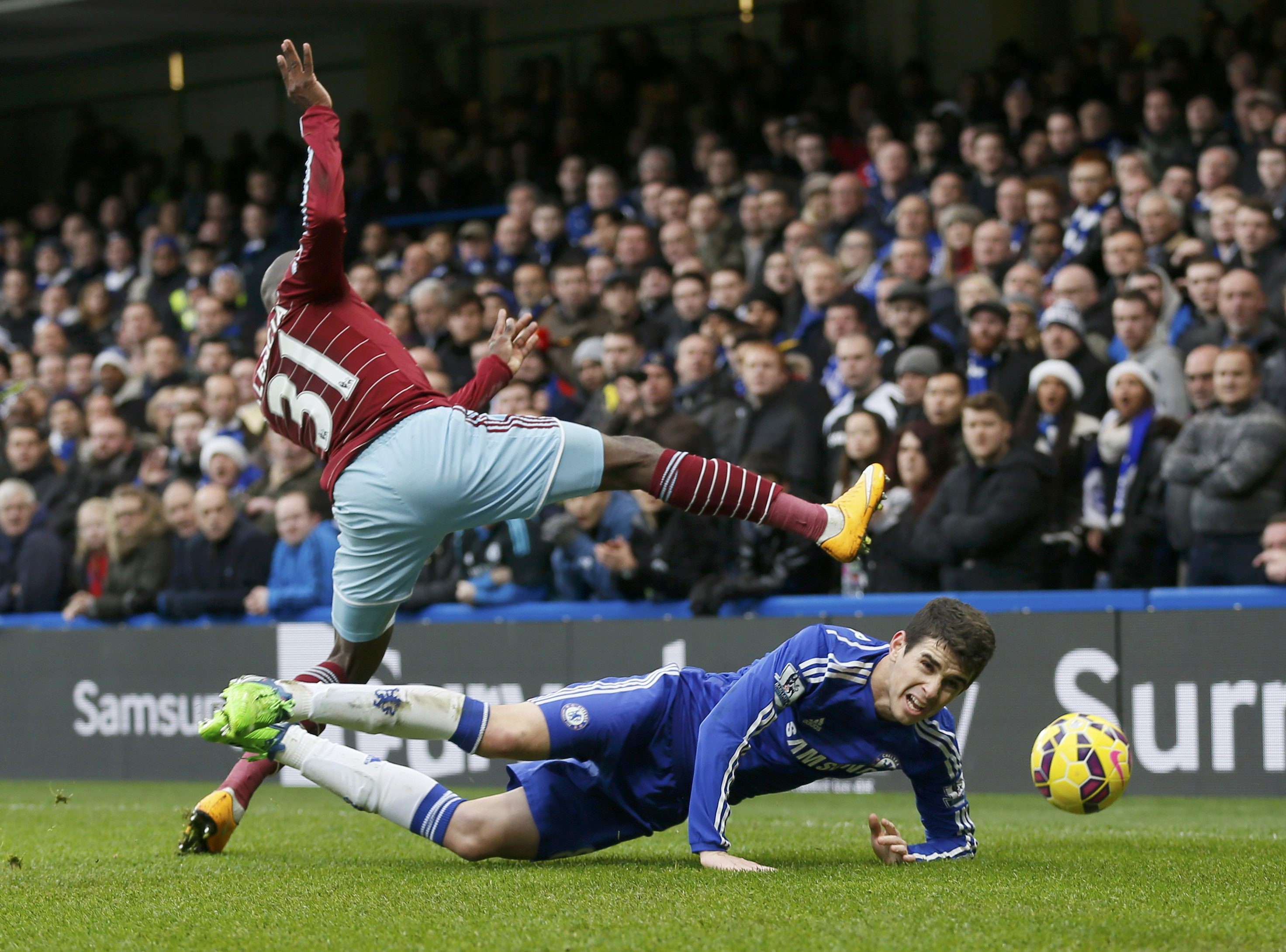 Chelsea's Oscar (ON GROUND) is challenged by West Ham United's Enner Valencia during their English Premier League soccer match at Stamford Bridge in London, December 26, 2014. REUTERS/Stefan Wermuth (BRITAIN - Tags: SOCCER SPORT) FOR EDITORIAL USE ONLY. NOT FOR SALE FOR MARKETING OR ADVERTISING CAMPAIGNS. EDITORIAL USE ONLY. NO USE WITH UNAUTHORIZED AUDIO, VIDEO, DATA, FIXTURE LISTS, CLUB/LEAGUE LOGOS OR 'LIVE' SERVICES. ONLINE IN-MATCH USE LIMITED TO 45 IMAGES, NO VIDEO EMULATION. NO USE IN BETTING, GAMES OR SINGLE CLUB/LEAGUE/PLAYER PUBLICATIONS.
