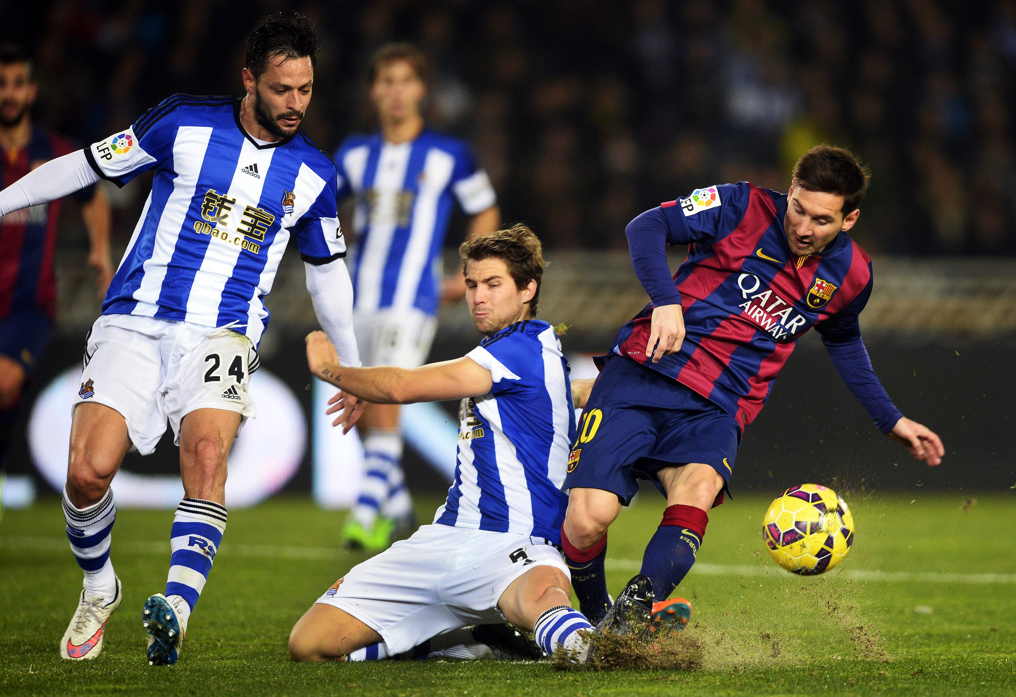 Barcelona's Lionel Messi (R) fights for the ball with Real Sociedad's Inigo Martinez (C) and Alberto de la Bella during their Spanish first division soccer match at Anoeta stadium in San Sebastian January 4, 2015. REUTERS/Vincent West (SPAIN - Tags: SPORT SOCCER)