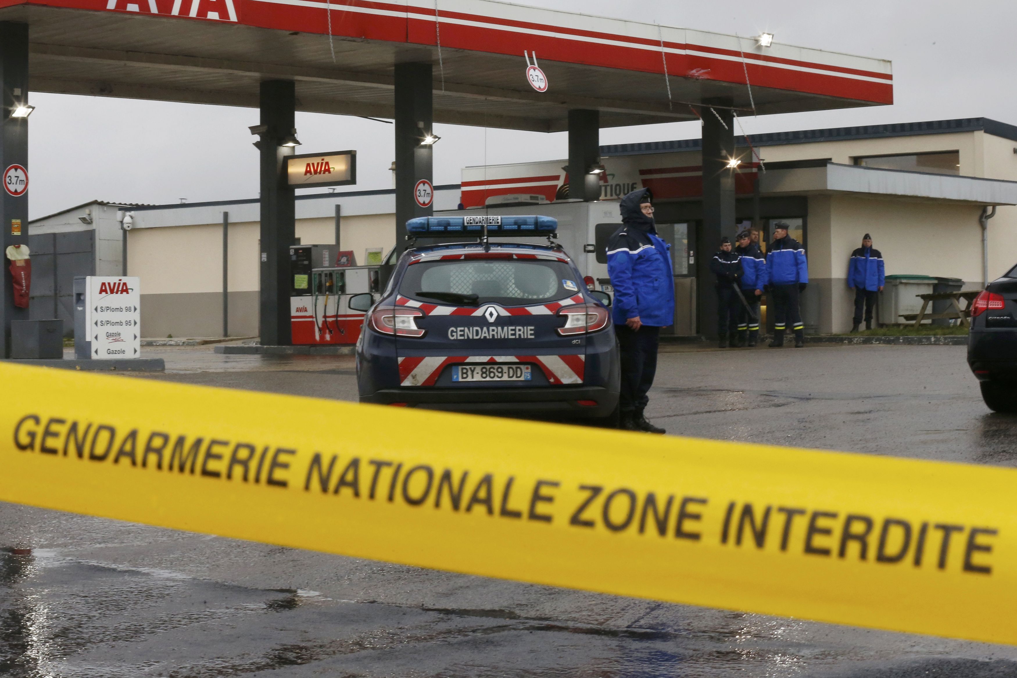 A Gendarmerie cordon is seen at a gas station in Villers-Cotterets, north-east of Paris, January 8, 2015, where armed suspects from the attack on French satirical weekly newspaper Charlie Hebdo were spotted in a car. French police extended a manhunt on Thursday for two brothers suspected of killing 12 people at the weekly satirical newspaper Charlie Hebdo in Paris in a presumed Islamist militant strike that national leaders and allied states described as an assault on democracy. France began a day of mourning for the journalists and police officers shot dead on Wednesday morning by black-hooded gunmen using Kalashnikov assault rifles. French tricolour flags flew at half mast throughout the country. REUTERS/Pascal Rossignol (FRANCE - Tags: CRIME LAW MILITARY)