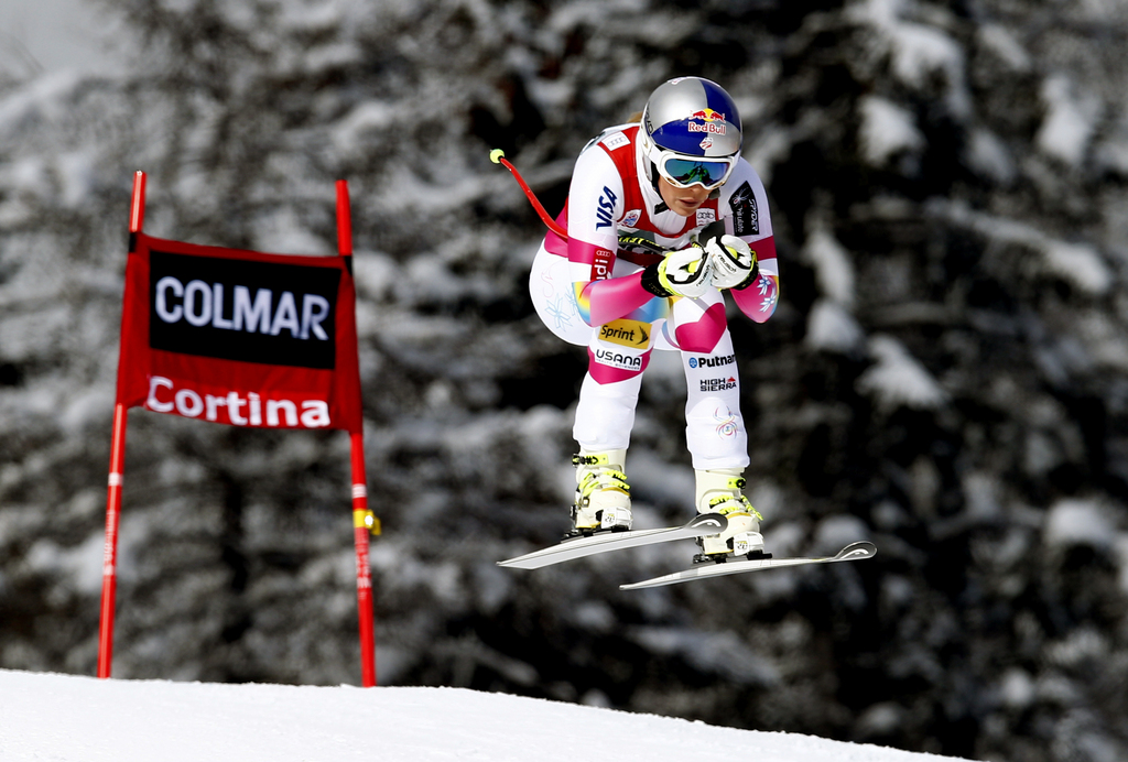 Lindsey Vonn takes a jump on her way to win an alpine ski, women's World Cup downhill in Cortina d'Ampezzo, Italy, Sunday, Jan. 18, 2015. Lindsey Vonn won a downhill Sunday to match Annemarie Moser-Proell's 35-year-old record of 62 World Cup wins, capping a comeback from two serious knee surgeries. (AP Photo/Alessandro Trovati)