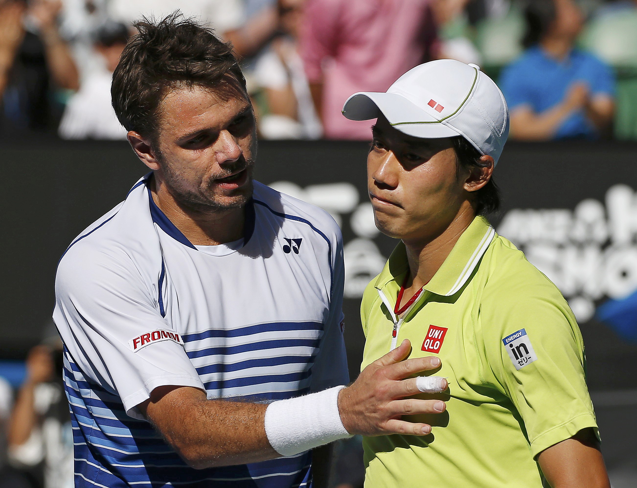 Kei Nishikori (R) of Japan reacts after shaking hands with Stan Wawrinka of Switzerland following his loss in their men's singles quarter-final match at the Australian Open 2015 tennis tournament in Melbourne January 28, 2015. REUTERS/Athit Perawongmetha (AUSTRALIA - Tags: SPORT TENNIS TPX IMAGES OF THE DAY)