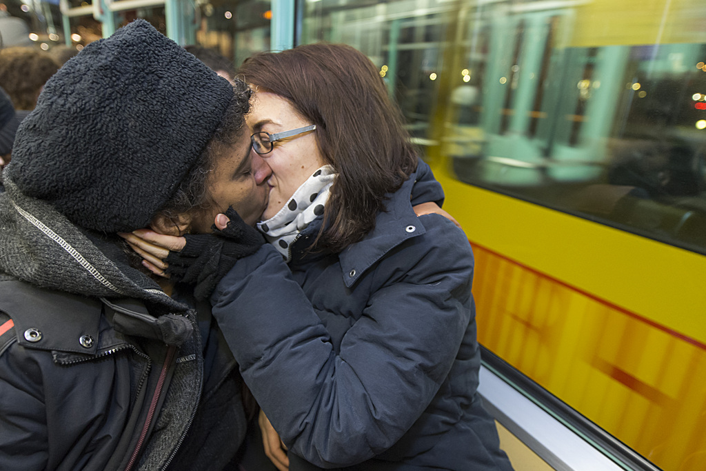 Leute kuessen sich bei einem Kiss-in im Tram der Linie 11 in Basel am Mittwoch, 4. Februar 2015. Nachdem die BLT (Baselland Transport AG) zunaechst die Kuss-Plakate des Jugentreffs Anyway nicht aufhaengen wollte, hatte Pink Cross zum Kiss-in im BLT-Tram aufgerufen. (KEYSTONE/Georgios Kefalas)