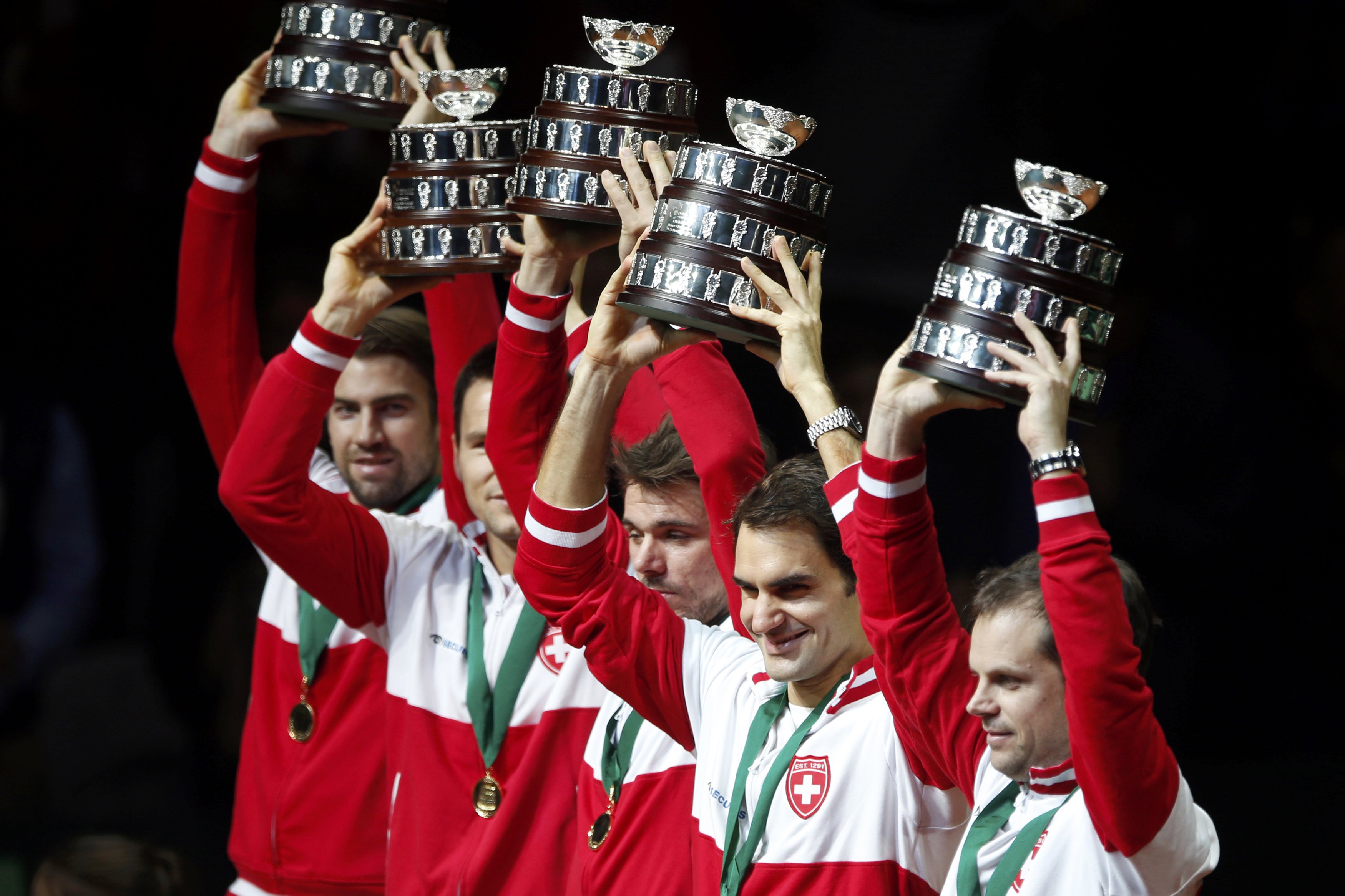 Switzerland's Roger Federer (2ndR) and tennis team captain Severin Luthi (R) raise their trophies as they stand with teammates after winning the Davis Cup final at the Pierre-Mauroy stadium in Villeneuve d'Ascq, near Lille, November 23, 2014. Roger Federer beat Richard Gasquet on Sunday to give Switzerland their first Davis Cup title with a 3-1 victory over hosts France in the final. REUTERS/Charles Platiau (FRANCE - Tags: SPORT TENNIS)