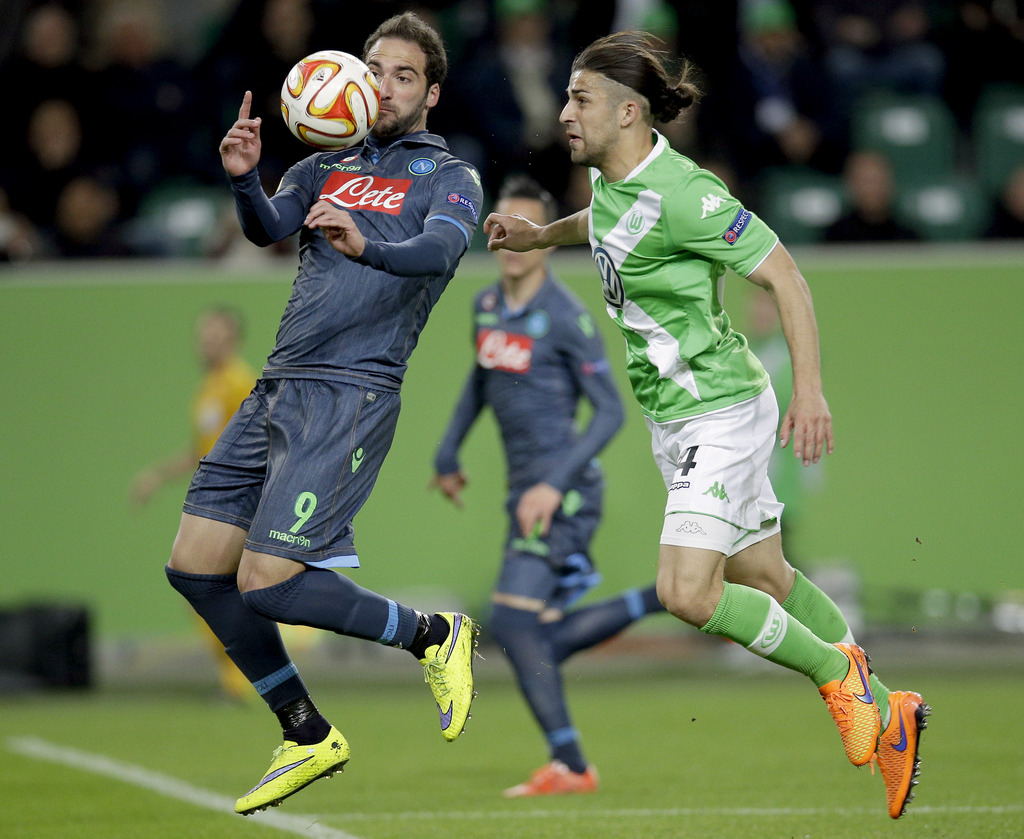 Napoli's Gonzalo Higuain, left, plays the ball to score his side's first goal during the Europa League first leg quarterfinal soccer match between VfL Wolfsburg and SSC Napoli in Wolfsburg, Germany, Thursday, April 16, 2015. At right is Wolfsburg's Ricardo Rodriguez. (AP Photo/Michael Sohn)