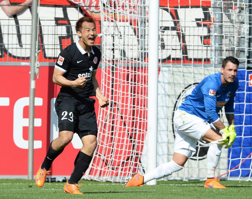 epa04710257 Mainz' Shinji Okazaki (L) celebrates after scoring the 1-0 lead against Freiburg's goalkeeper Roman Buerki (R) during the German Bundesliga soccer match between SC Freiburg and FSV Mainz 05 in Freiburg, Germany, 18 April 2015. ....(EMBARGO CONDITIONS - ATTENTION: Due to the accreditation guidelines, the DFL only permits the publication and utilisation of up to 15 pictures per match on the internet and in online media during the match.) EPA/PATRICK SEEGER