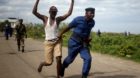 A policeman runs with a detained protester during a protest in Buterere neighbourhood of Bujumbura, Burundi May 12, 2015.  Po